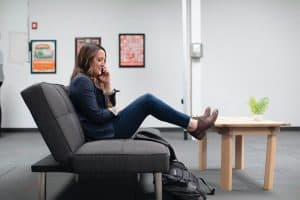 woman sitting on black office chair on phone for strengthening customer communications article