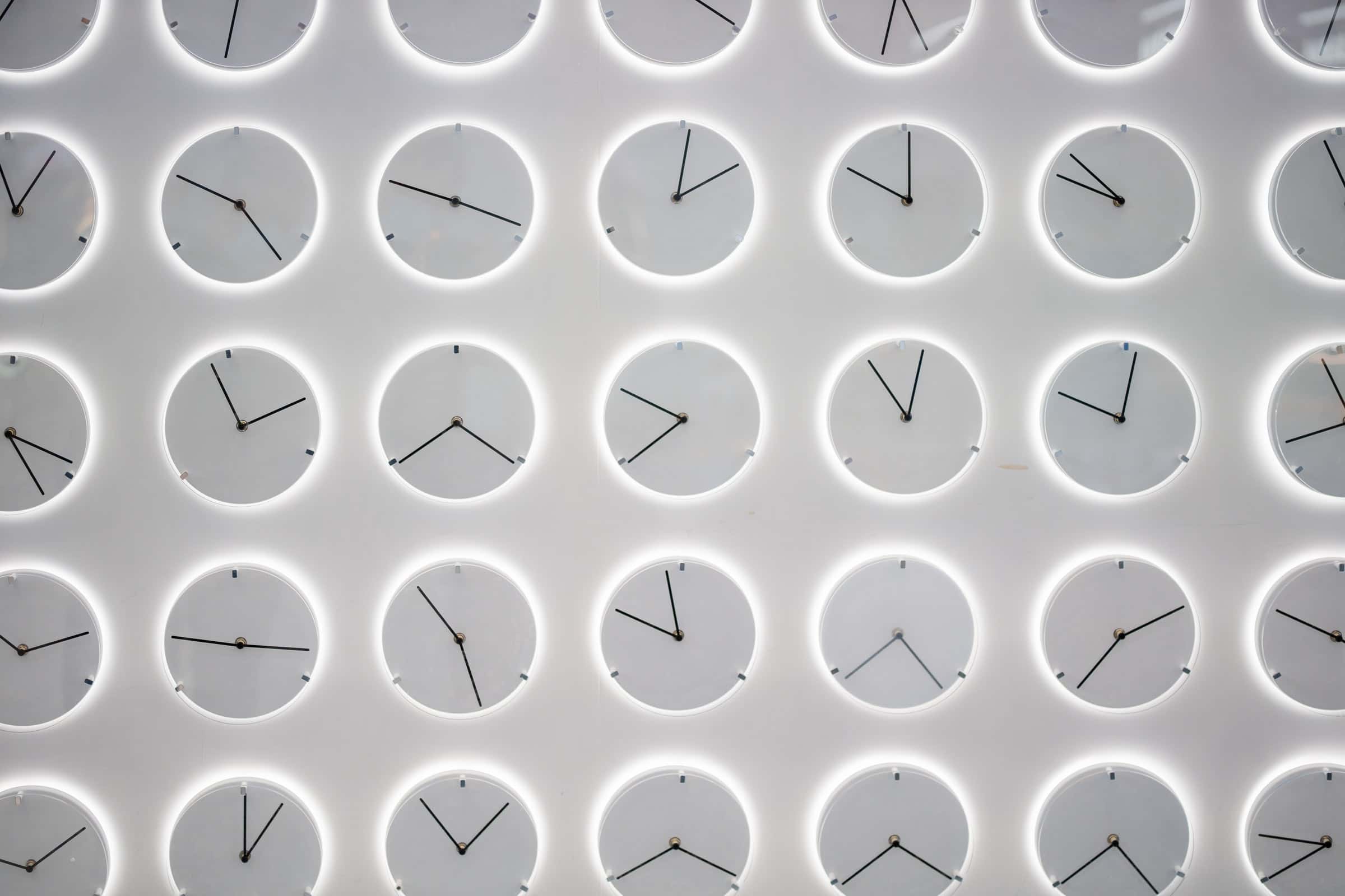 wall of neon white minimal clocks for simple crm article