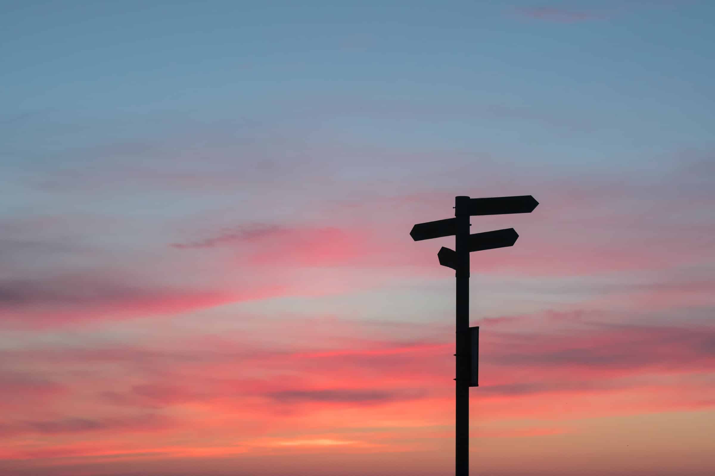 signpost in silhouette against sunset for pipeline tracking article